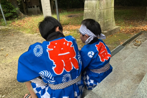 祭りはっぴを着る兄弟